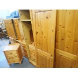 A pine bedroom suite, comprising triple wardrobe, five drawer chest, dressing table, dressing table