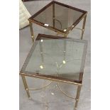 A pair of smoked glass and brass side tables.