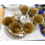 Silver plated serving trays and brass goblets.