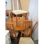 A Morris Furniture Company extending circular kitchen table and six matching chairs.