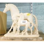 A resin sculpture of two horses, on onyx base.