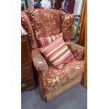 A wingback armchair, red and gold floral upholstery.