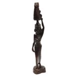 A Balinese carved wooden figure of a woman, with a comport of fruit and flowers upon her head, raise