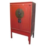 A Chinese red lacquer wedding cabinet, with a pair of doors opening to reveal a single shelf above t