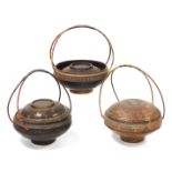 Three Chinese lacquer rice or grain baskets, variously decorated, with double loop handles and lids.