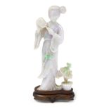 A Chinese carved jadeite figure of a lady with a fan, modelled standing against a pot of flowers, wi