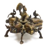 An early 20thC Indian brass Kumkum spice box, of five lidded star form, with bird and peacock finial