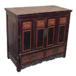 A Chinese black and red lacquered cupboard, with a pair of carved panelled doors opening to reveal s