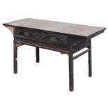 A Chinese red stained hardwood side table, with two carved drawers, over a carved frame, raised on s