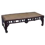 A Chinese stained elm and rattan food table, with a pierced a roundel carved frieze, raised on squar