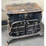 An early 19thC Esse cast iron wood burning stove, with a pierced hinged lid, the front a reserve cre
