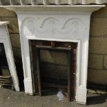 An Edwardian Adam style fire surround, white painted with a dentil moulded pediment, above a carved