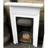 An Edwardian cast iron and white painted wooden bedroom fire surround, 110cm x 68cm.