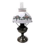 An early 20thC Aladdin model II oil lamp, with a glass chimney and floral painted white glass shade,
