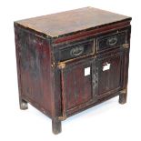 A Chinese hardwood side cupboard, with two drawers over a pair of cupboard doors, raised on stiles,