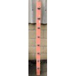 A vintage salmon pink painted coat rack, for wall mounting, with eight hooks, 178cm wide.
