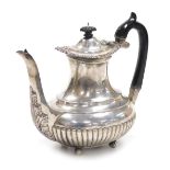 A Victorian silver semi fluted coffee pot, with embossed foliate decoration to the top rim, raised o