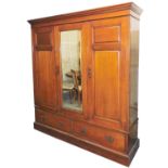 A Victorian mahogany compactum wardrobe, the outswept pediment over one central door, inset bevelled