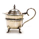 An Edward VII silver mustard pot, with a hinged lid, raised on four feet, with blue glass liner, Bir