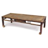 A Chinese hardwood rectangular occasional table, with a rattan top, raised on square legs united by