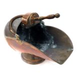A Victorian copper helmet shaped coal scuttle, with shovel, 49cm wide.