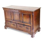 A George III oak and mahogany mule chest, with a hinged lid over a triple panelled front, flanked by