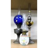 Three oil lamps, two with metal bases one ceramic.