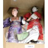 Two oriental dolls and a pair of silk shoes.