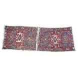 A pair of Heriz prayer rugs, stitched together, each with three central medallions, against a red fi