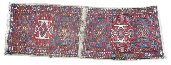 A pair of Heriz prayer rugs, stitched together, each with three central medallions, against a red fi