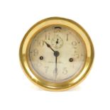 A brass cased ship's clock, the circular silvered dial bearing Arabic numerals, bearing name Seth Th