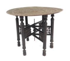 An early 20thC Indian copper tray topped table, with pierced and embossed decoration of repeating fi