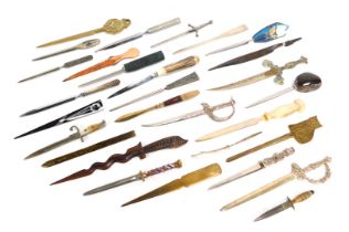 A group of letter openers, varying designs, to include a letter opener with a carved hard stone hand