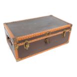 An early 20thC brown and tan leather bound trunk, with brass fittings, named to the lid for M. Dobne