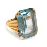 A 9ct gold dress ring, with rectangular cut light blue stone, in a raised basket with fluted design
