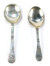 Two white metal caddy spoons, each with a circular bowl initialled verso, both handles bright cut de