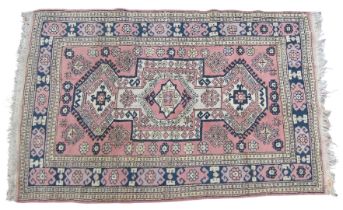 A Kilim pink ground rug, the central geometric fields set with three large and two smaller medallion