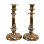 A pair of early 20thC copper and pewter candlesticks, each copper candlestick decorated with pewter