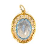A 9ct gold pendant, with central light blue stone, possibly a topaz, in a pierced outer frame, one c