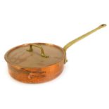 A shallow copper saucepan and lid, with brass handle, 26cm diameter.