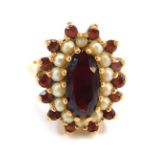 A 9ct gold cluster ring, the oval cluster set with garnet and seed pearls, each in claw setting, on