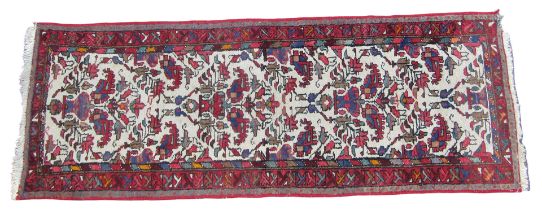 A Turkish green ground runner, the central field decorated with three vases of flowers, within repea