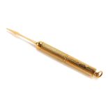 A 9ct gold propelling tooth pick, with engine turned decoration, 5.5g.