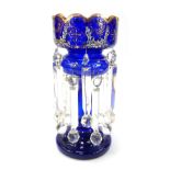 A Victorian Bristol Blue glass lustre, decorated with painted flowers and gilt heightened decoration