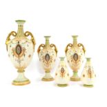 A group of Crown Devon blush pottery, comprising a graduated set of three two handled vases,