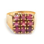 A 9ct gold dress ring, the square set panel with nine garnets, each in claw setting, on a plain yell