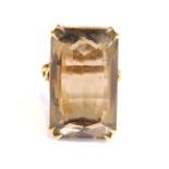 A 9ct gold dress ring, of chunky design, set with rectangular cut smoky quartz, in a raised basket s