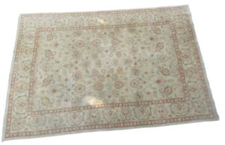 A Caucasian green ground rug, decorated with floral and foliate motifs, within repeating floral bord
