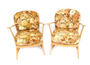 A pair of Ercol beech framed armchairs, model 334, each with a loose floral upholstered seat and bac