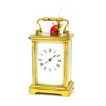 A 20thC brass cased carriage clock, a rectangular white enamel dial bearing Roman numerals, barrel k